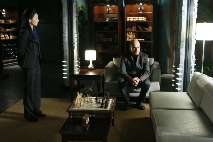 Shen Xiaoyi (Tamlyn Tomita) visits Woolsey (Robert Picardo) in his quarters.
