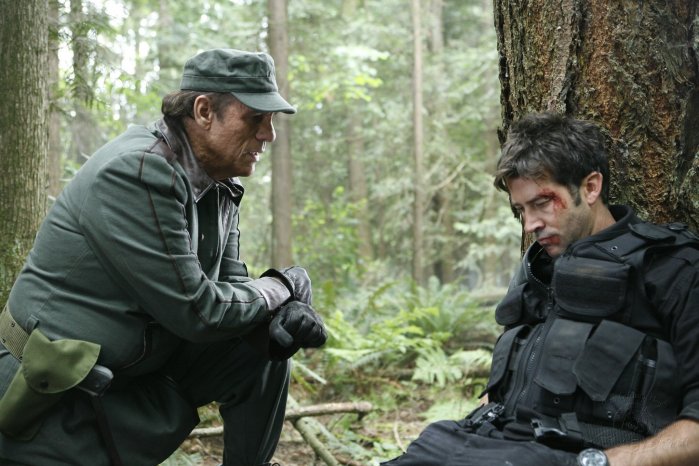 Kolya (Robert Davi) subjects Sheppard (Joe Flanigan) to beating and torture.
